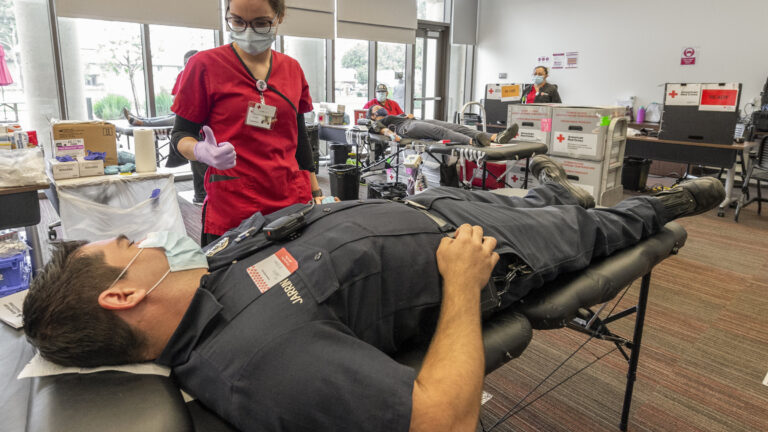 Red Cross technician works on helping a man during 