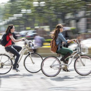 Two students biking on the USC campus