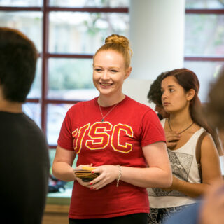 A girl standing talking with another student.