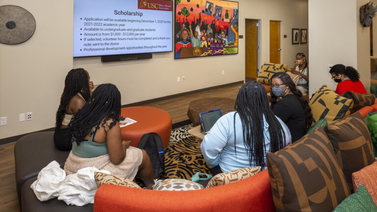 A group of five students sitting on couches in the Center for Black Cultural and Student Affairs lounge.