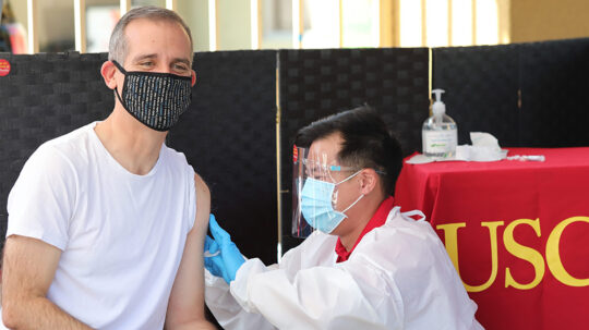 Former Los Angeles Mayor Eric Garcetti receives a flu shot from Richard Dang, assistant professor at USC Mann