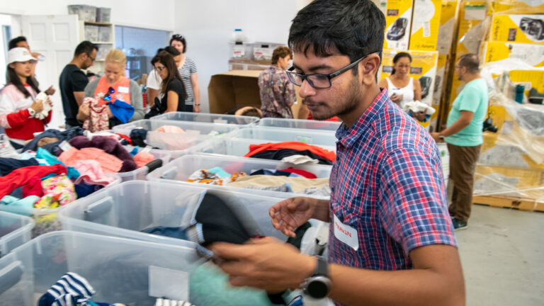 Student sorts through boxes of clothes.