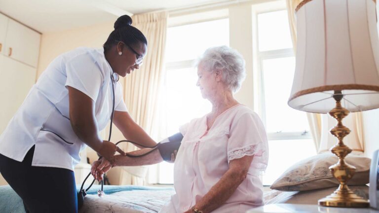 Nurse checking blood pressure of female patient