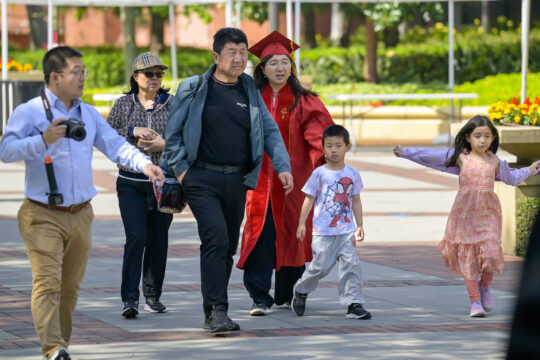 Graduating student with family and small children on campus
