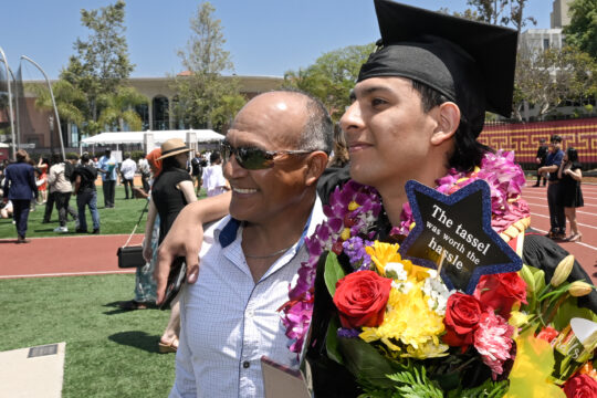 A USC graduate takes a pose with his father
