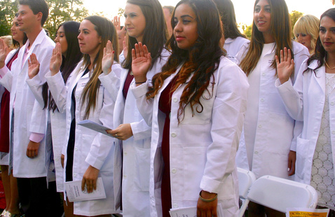 USC Chan students smile for the camera with their white lab coats