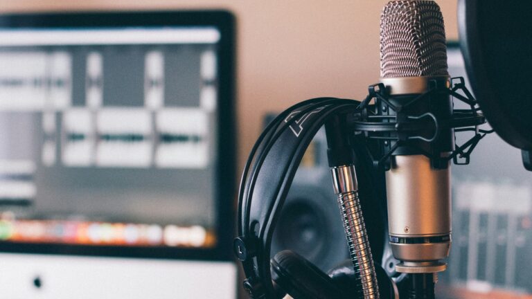A black microphone with a computer in the background