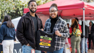 USC Mann PhD students Atham Ali and Michelle Kale holding up a USC Black History Month Block Party t-shirt, on USC Health Sciences Campus’ Pappas Quad.