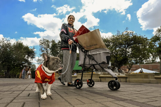 a person with a dog on campus wearing USC gear