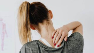 A woman rubbing her back from pain