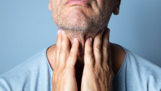 A male patient rubbing his throat