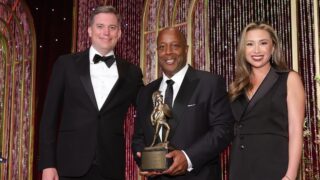 USC Alumni Awards dinner co-chairs Peter Brejcha JD ’09 (left) and Ruth Benton ’08 (right) join Alumni Merit Award honoree Eric Holoman ’83 (center) at the 92nd USC Alumni Awards on April 18, 2026. (USC Photo/Greg Grudt/ SteveCohn Photography)